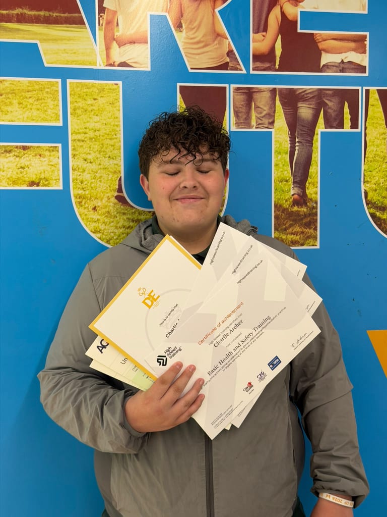 A student celebrating achievement with a stack of certificates