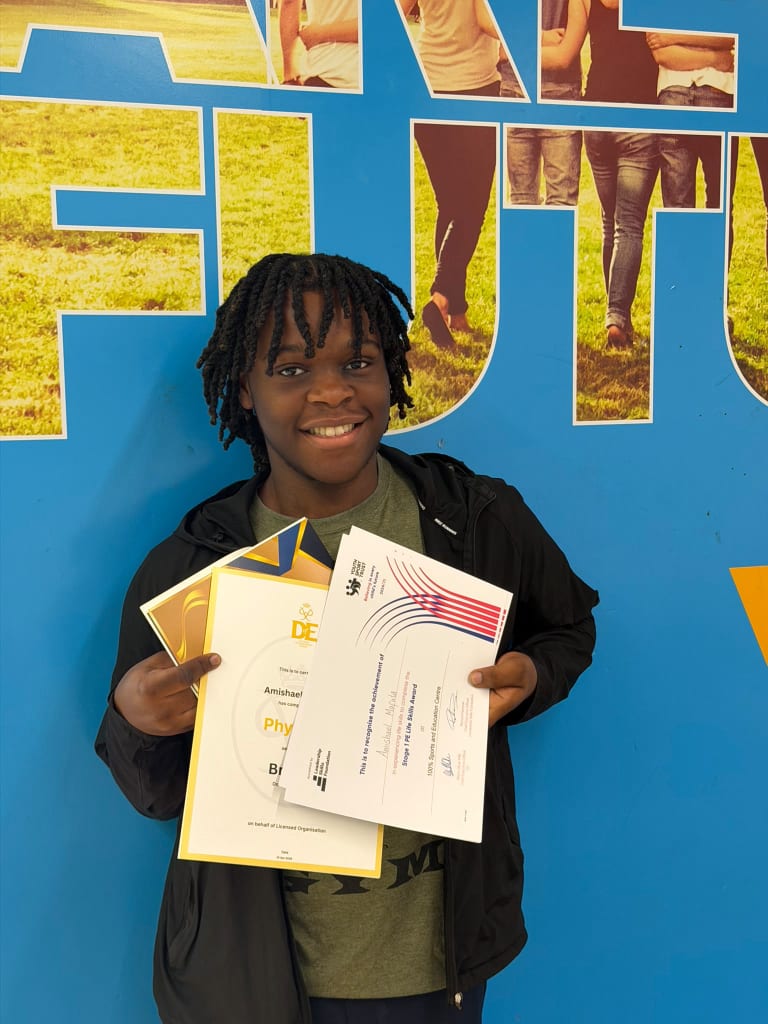 A student proudly holding Duke of Edinburgh and leadership award certificates
