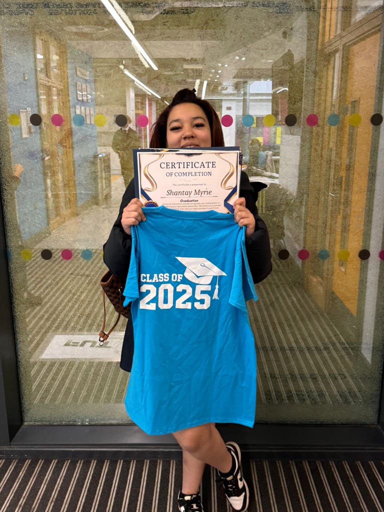 A student celebrating achievement with a certificate of completion